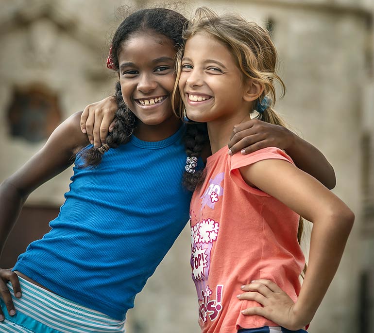 Young Cuban girls hugging.