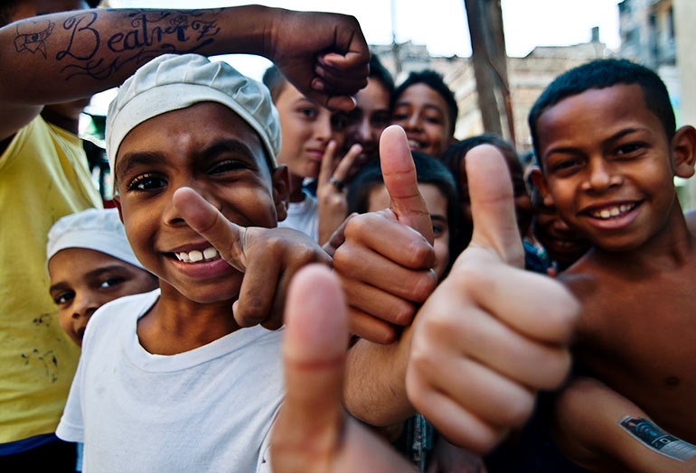 Cuban kids give thumbs up to American visitors.